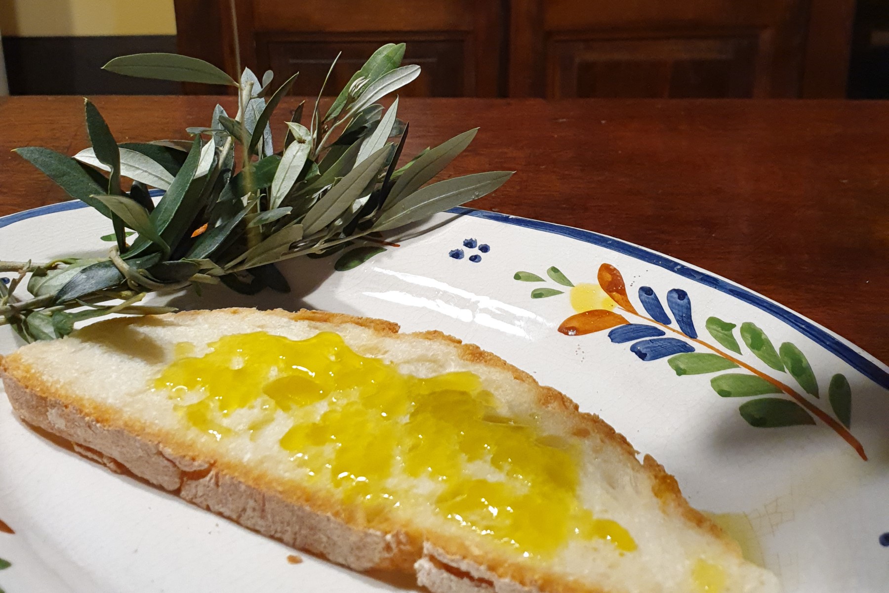 Olive oil from Italy: fresh olive oil on bruschetta with an olive branch.
