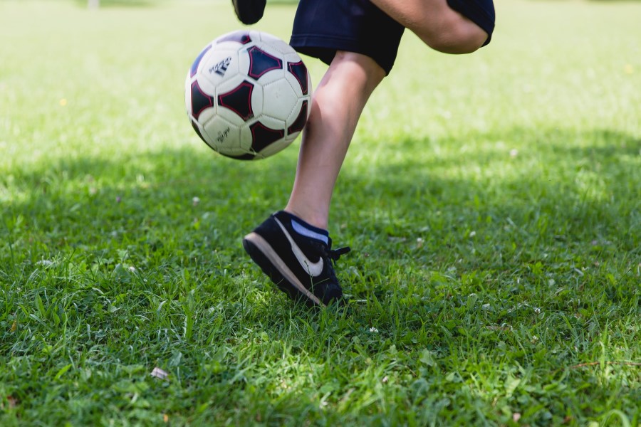 Fußball spielen Kind im Garten