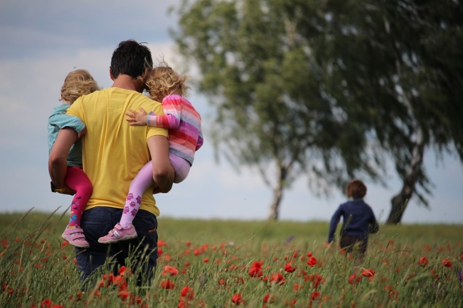 Familie mit Kindern spaziert in der Toskana Mohnblumen