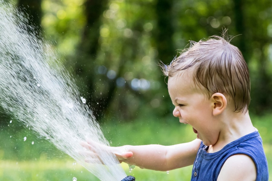 Kind spielt mit Wasser im Garten Toskana Ferienhaus